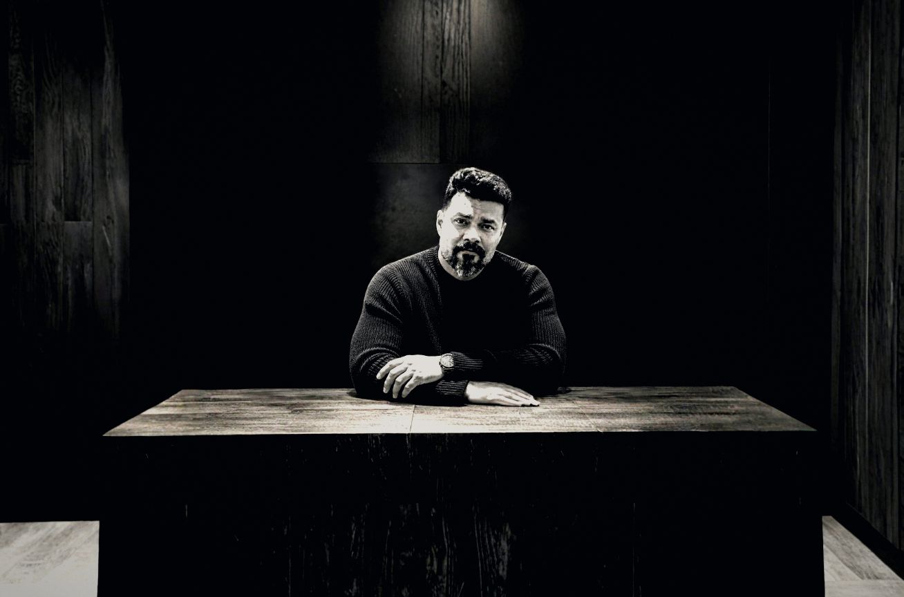 Avishek Biswas seated at a dark oak table in a timber-panelled room.